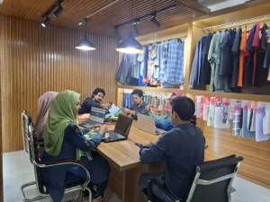 eam collaborating on garment design in a modern, wood-accented clothing studio.