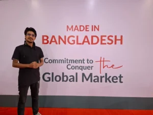 Person in front of a “Made in Bangladesh” sign symbolizing dedication to global trade and national pride