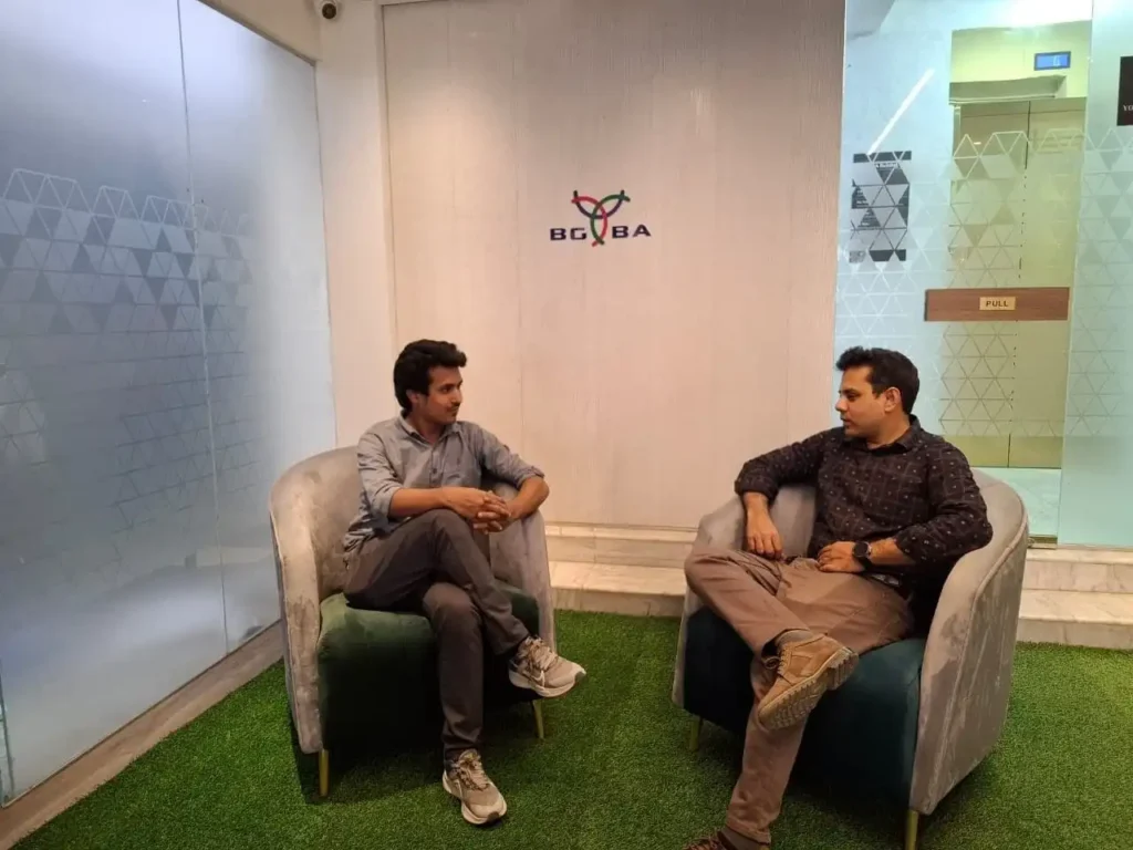 Two professionals in a modern office lounge, engaged in a discussion