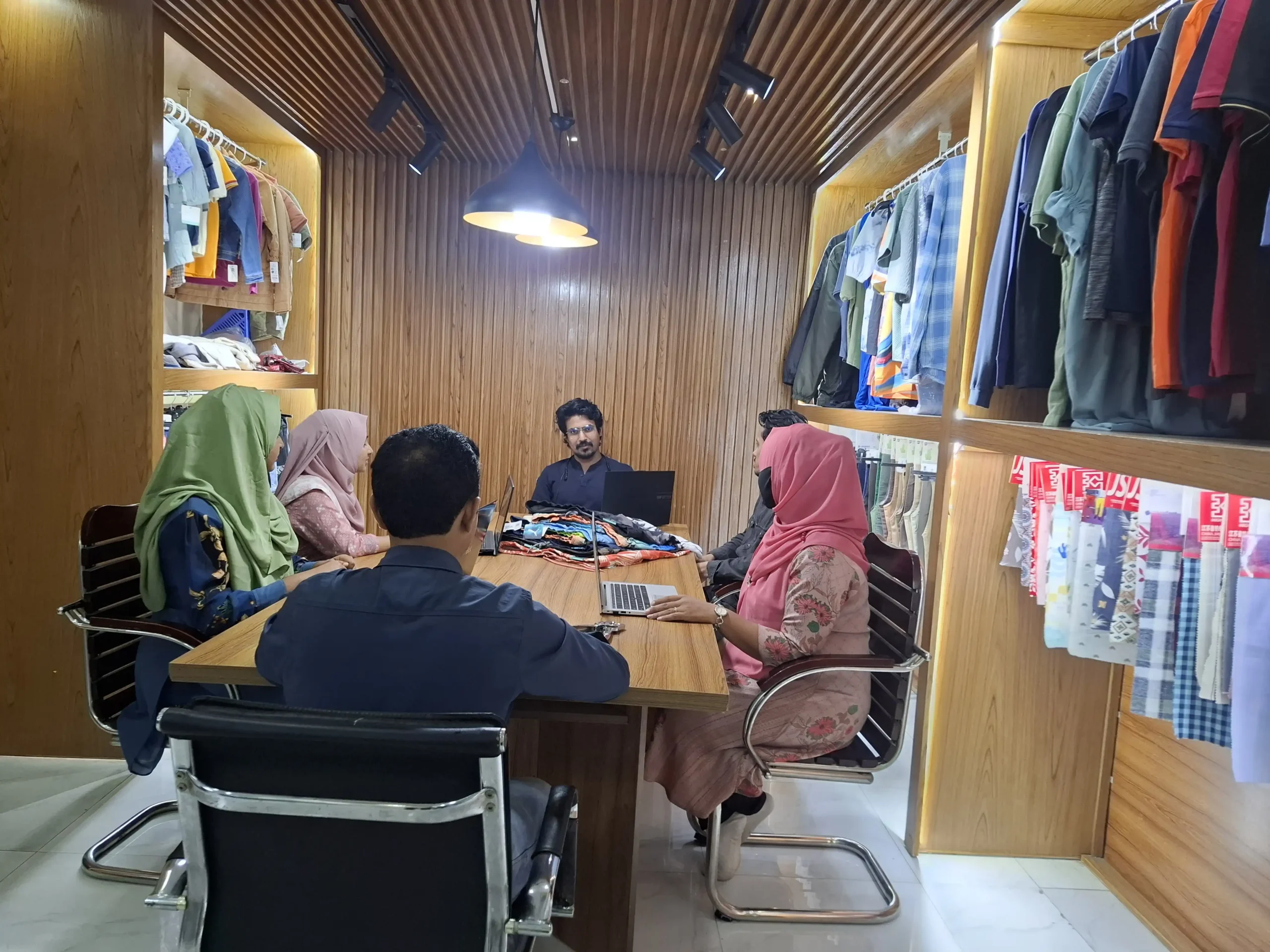 Apparel design team meeting discussing fabric swatches and new collections in a modern office.