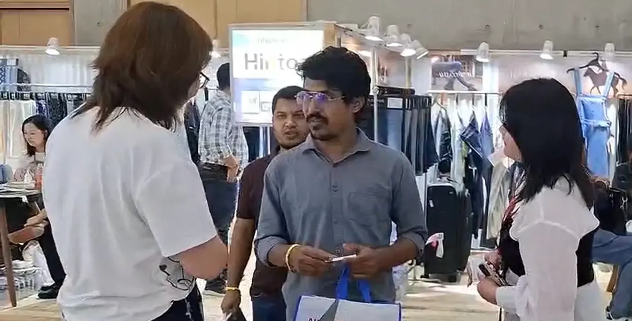 Antor Hossain talking with international buyers at a denim and apparel trade show in Asia.