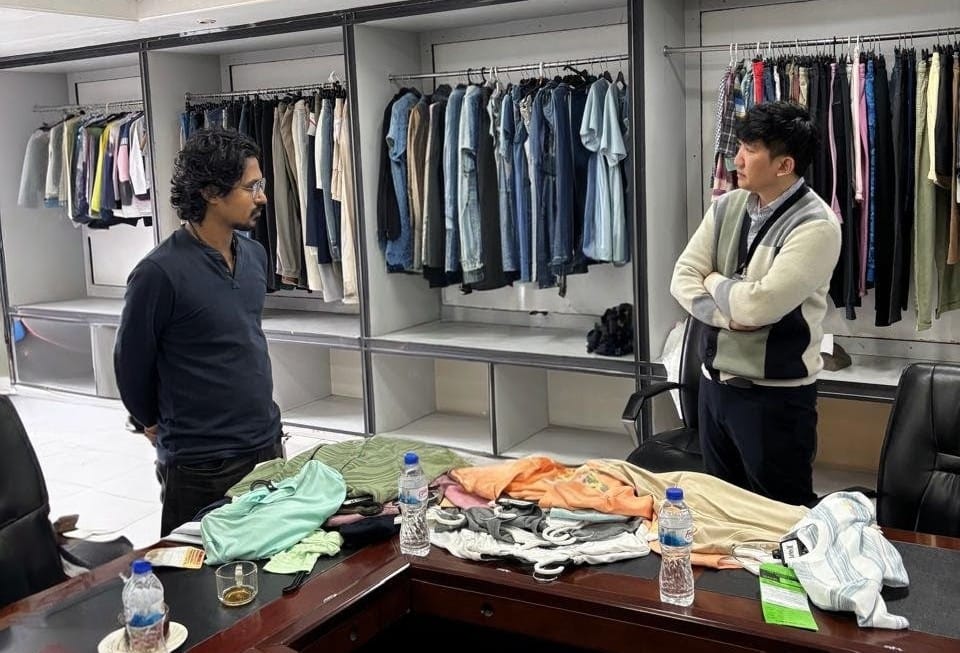 Antor Hossain in a Bangladesh garment showroom reviewing samples with an international buyer