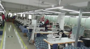 Woven shirt sewing line in a Bangladesh garment factory, with operators working at industrial machines