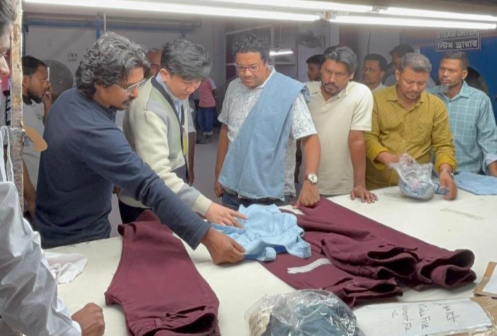 Antor Hossain reviewing garment samples with a factory team on the production floor in Bangladesh.