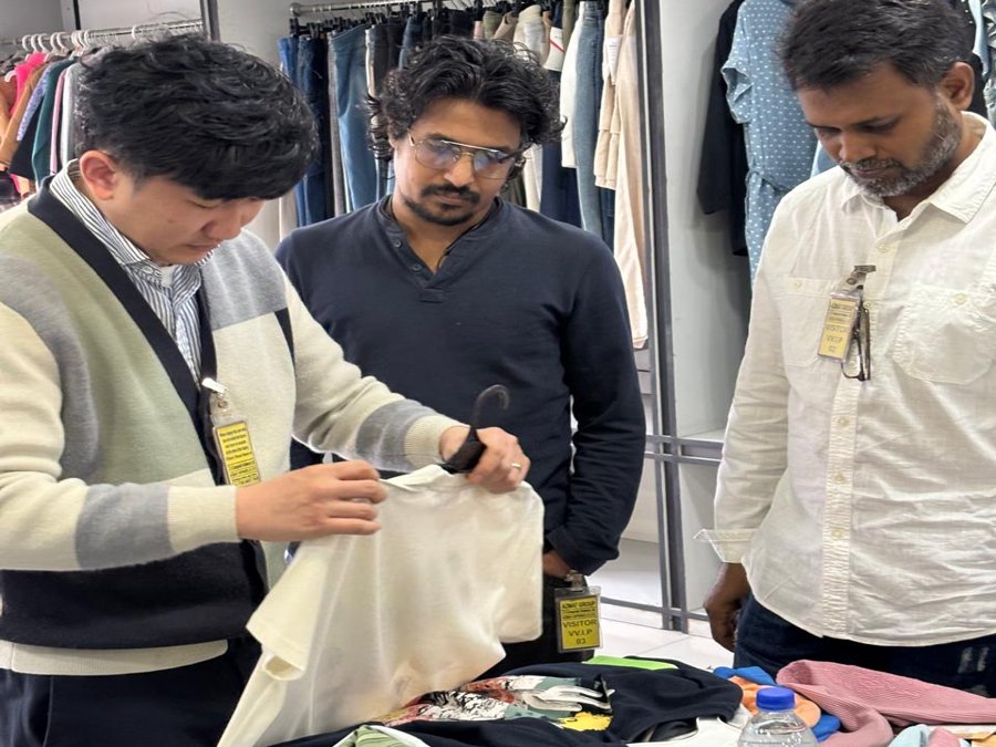 International buyer and Bangladesh merchandising team reviewing knit and jersey samples in a showroom