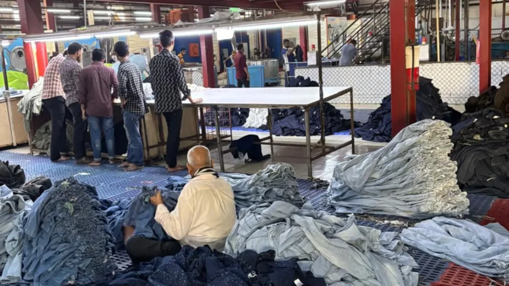 Denim washing facility in Bangladesh with workers handling jeans after laundry