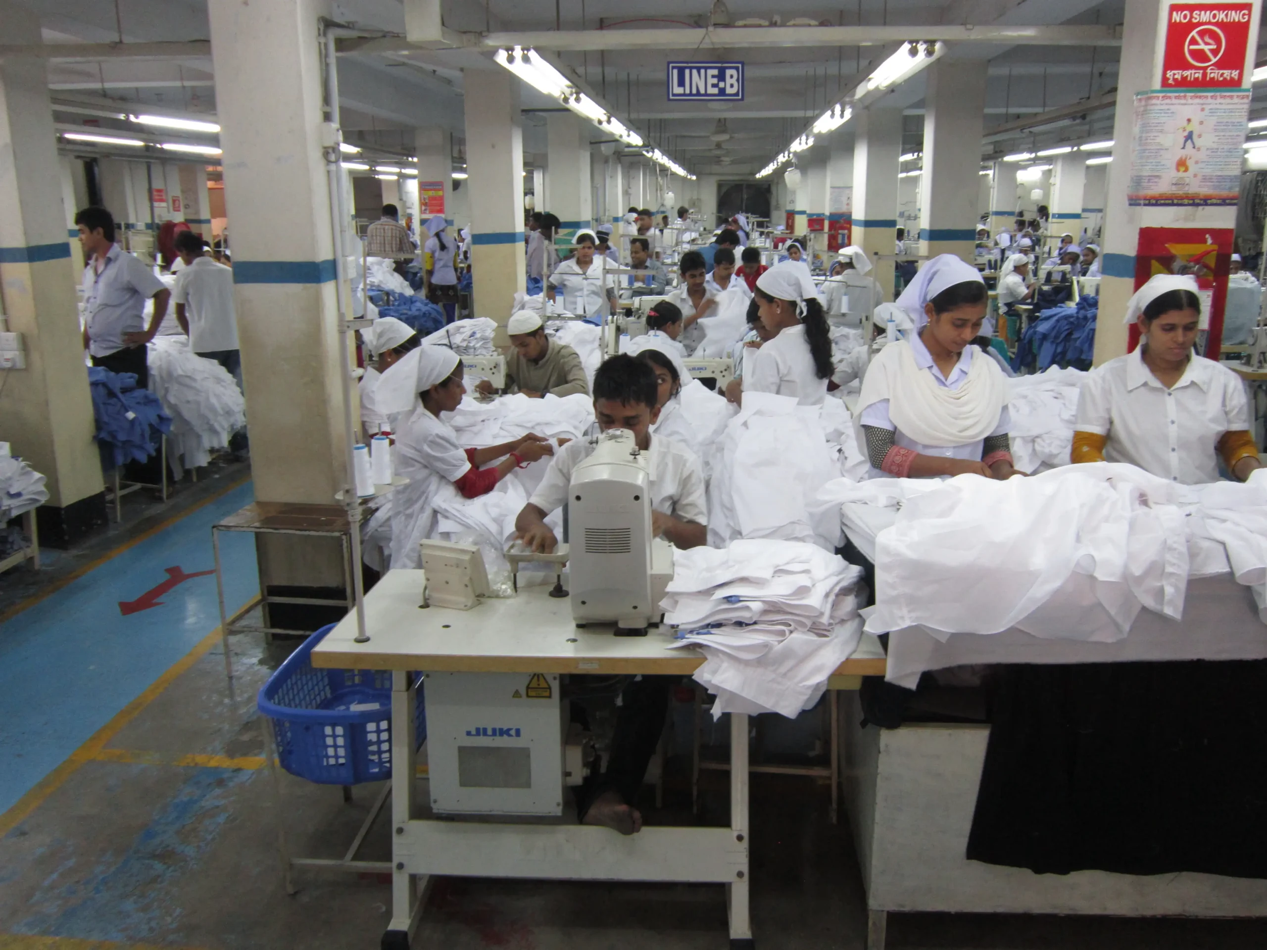 Sewing operators working on a woven shirt production line in a Bangladesh garment factory